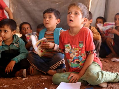 Niños refugiados asisten a clase en el campo de desplazados de Atmeh, en Idlib, al norte de Siria.