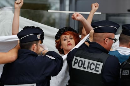 Policías tapan a una activista del colectivo Femen durante una protesta  frente a la casa del Tribunal de París para apoyar al artista ruso Piotr Pavlenski, detenido en la prisión Fleury-Merogis desde octubre de 2017 después de prender fuego en una sucursal del banco de Francia. 