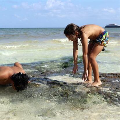 Turistas disfrutan de la formación de ojos de agua el 2 de julio 2024 en Playa del Carmen, Quintana Roo (México).