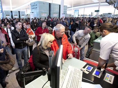 Un grupo de pasajeros hacen cola, ayer, para facturar sus maletas en la T-1 del aeropuerto de El Prat.
