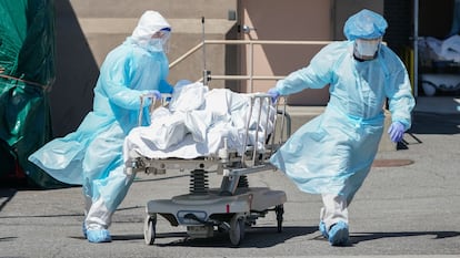 Dos sanitarios trasladan un cadáver en el hospital Wyckoff de Nueva York, en abril.