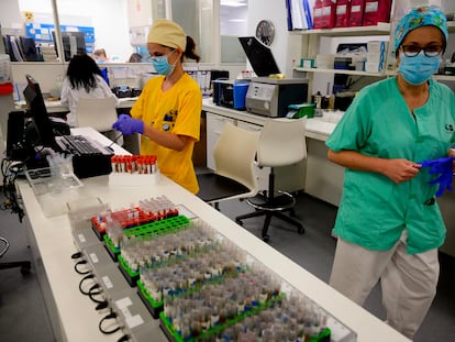 Microbiologists in Madrid's Gregorio Marañón hospital process samples ready for PCR coronavirus testing.