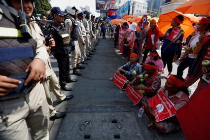 Activistas camboyanas se manifiestan ante un cordón policial por el Día internacional de la Mujer este viernes en Phnom Penh (Camboya).