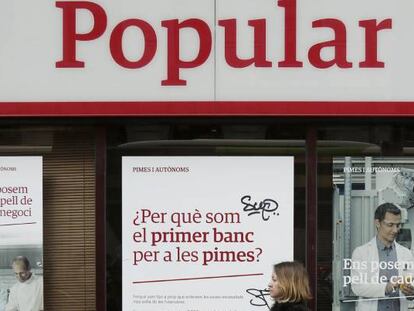 Una mujere pasa ante una oficina del Banco Popular en el Paseo de Gracia, Barcelona.