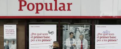 Una mujere pasa ante una oficina del Banco Popular en el Paseo de Gracia, Barcelona.