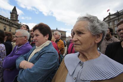 La gente asiste al funeral en el exterior de la catedral con gesto cariacontecido. 