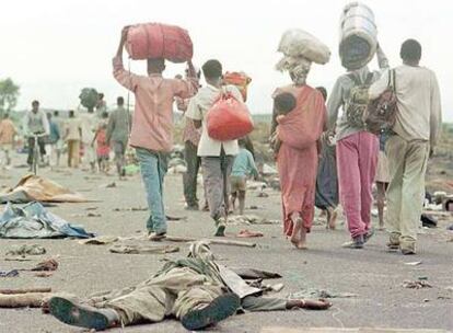 Refugiados hutus ruandeses transitan por una carretera de Zaire a Ruanda ante el cuerpo de un soldado zaireño cerca de Goma en 1996. 
/ reuters
Rafael del Águila.