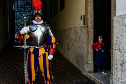 Un niño observa a un guardia suizo que sostiene su espada antes de la ceremonia anual de juramento de los nuevos reclutas.