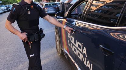 Un policía abre un coche policial en Valladolid.