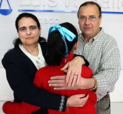Los padres abrazan a su hija.