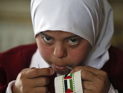 Una niña borda en una cinta banderas palestinas en el Centro Right to Live que acoge a menores con deficiencias psíquicas en Gaza