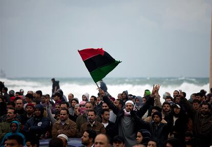 Un libio ondea una bandera tricolor previa al régimen de Gadafi. Bengasi es una ciudad liberada donde los opositores se han hecho con el control.