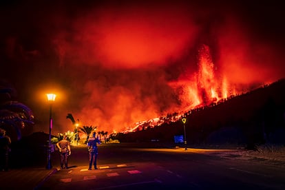 Police officers stand guard near the volcanic eruption.