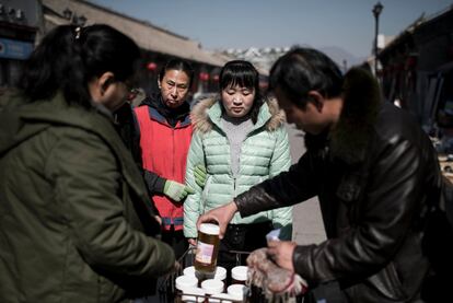 Song Xiao Yan, de 62 años, (2L) diagnosticada con esquizofrenia compra un poco de mermelada con sus colegas en un mercado fuera de la unidad abierta residencial de Vila Rosa para las personas con condiciones de salud mental en el distrito de Yinqing, Beijing, China. Todos los días cuatro de los pacientes van a comprar al mercado para ayudar a los cocineros de Vila Rosa. Como parte de la terapia, todo el mundo tiene un papel y responsabilidad para hacer una parte del trabajo diario.