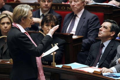 La ministra de Exteriores, Michèle Alliot-Marie, se dirige al primer ministro, François Fillon, ayer en el Parlamento.