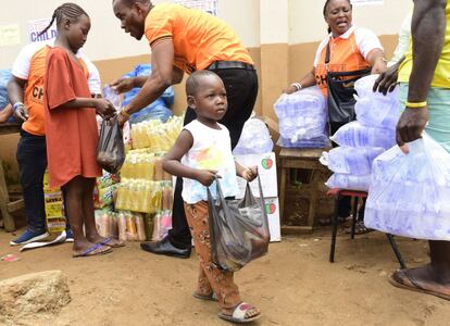 Un niño recibe una bolsa de suministros y ayuda de voluntarios cerca de Freetown, la capital de Sierra Leona. 