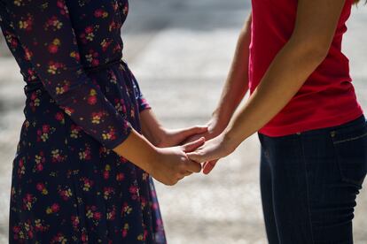 Dos mujeres se cogen de las manos en un parque.