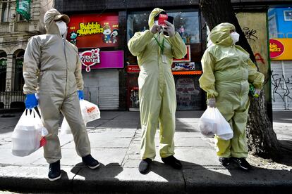 Tres personas ataviadas con trajes de protección en La Paz.