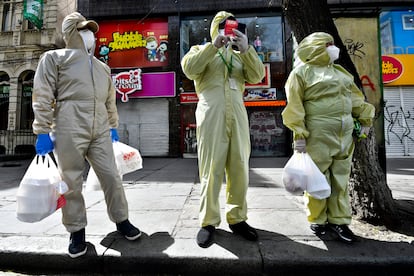 Tres personas ataviadas con trajes de protección en La Paz.