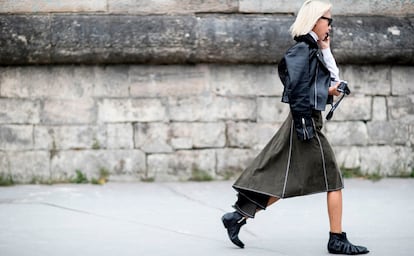 La melena platino sigue triunfando. Aquí es la protagonista de un look en tonos oscuros con falda asimétrica y botines planos.