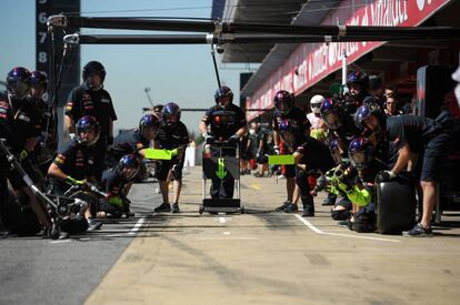 Los mecanicos de la escuderia Toro Rosso, a la espera de que uno de sus bólidos entre en 'boxes' para sustituir los neumáticos.