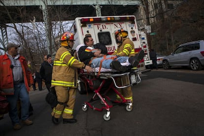 El personal de emergencia evacúan a una víctima del lugar del descarrilamiento de un tren Metro-North en el barrio del Bronx de Nueva York