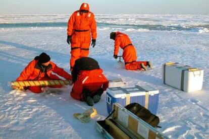 Científicos trabajan sobre el hielo junto al barco <i>Amundsen.</i>