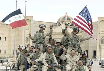 Los <b><i>marines</b></i> enarbolan banderas de EE UU y de Irak frente al palacio de Tikrit, tras controlar la ciudad.