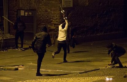 Los manifestantes sostienen barras de metal durante la protesta tras la muerte de un vendedor ambulante en el distrito de Lavapiés.