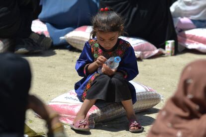 Una niña se sienta en un saco de arroz distribuido a personas necesitadas por el Ministerio de Refugiados afgano en cooperación con China, este miércoles en Kabul (Afganistán).
