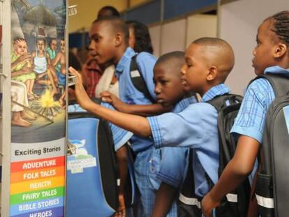 Ni&ntilde;os equipados con los materiales del Port Harcourt World Capital Book. 