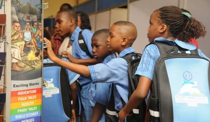 Ni&ntilde;os equipados con los materiales del Port Harcourt World Capital Book. 