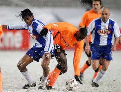 Fredson y Sissoko disputan sobre la nieve un balón ante De la Peña.