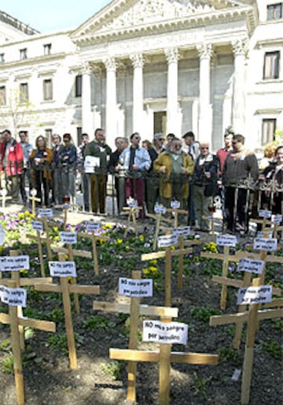 Miembros del Foro Social de Madrid y de IU <i>plantan</i> un cementerio de la guerra frente al Congreso.