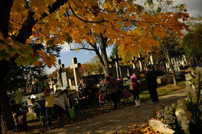 Varias personas visitan las tumbas del cementerio de Pamplona (España).