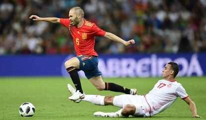 El mediocampista español Andrés Iniesta disputa un balón con el mediocampista de Túnez Elyess Skhiri.