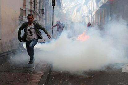 Un hombre se aleja del humo durante los disturbios ocurridos durante una manifestación en Quito, este lunes.