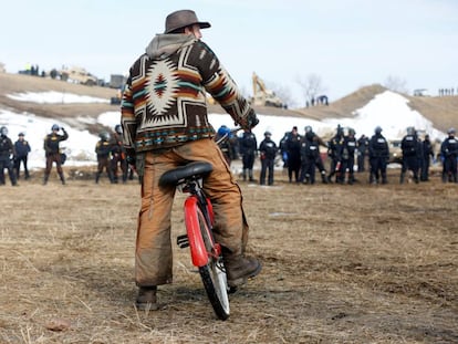 Un hombre observa el avance de las fuerzas de seguridad en el campamento contra el oleoducto Dakota Access.