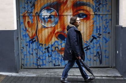 Un hombre pasea por una calle del Barrio de las Letras frente a un mural de Zaida Escobar.