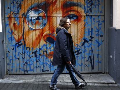 Un hombre pasea por una calle del Barrio de las Letras frente a un mural de Zaida Escobar.