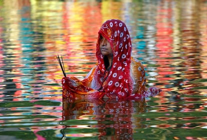 Una mujer hindú adora al dios del Sol en las aguas de un lago en Agartala (India). Durante el Chhath, se realizan rituales para agradecer a Suria, dios del Sol, mantener la vida en la tierra.