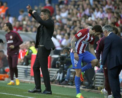 El defensa del Atlético de Madrid Sime Vrsaljko abandona el campo lesionado ante su entrenador, el argentino Diego Simeone.