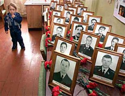 Un niño pasa junto a los retratos de las víctimas del <i>Kursk</i>.