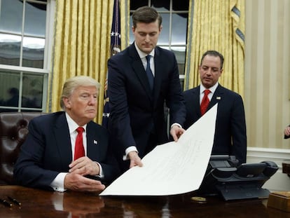 Porter entrega un documento a Trump el 20 de enero de 2017, en sus primeras horas como presidente