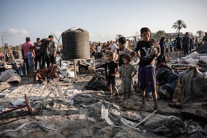 Varios palestinos observan la zona afectada tras el ataque aéreo en el campamento de Al Mawasi, en la ciudad de Jan Yunis.
