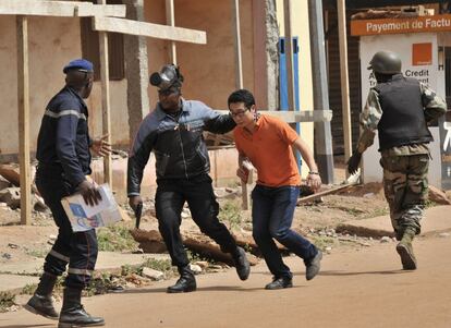 Fuerzas de seguridad de Mali evacuan a un hombre del hotel.