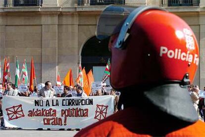 Los participantes en la protesta de ayer en Pamplona, vigilados por efectivos de la Policía Foral.