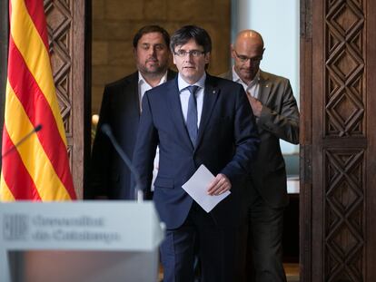 El entonces presidente Carles Puigdemont, acompañado de los consejeros Oriol Junqueras (izquierda) y Raül Romeva, en marzo de 2017.