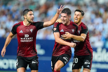 El jugador del Mirandés Joaquin Panichelli (centro) celebra un gol contra el Málaga en La Rosaleda junto a Tachi (izquierda) y Alberto Reina (derecha) el 24 de agosto.