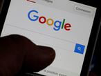 FILE PHOTO: A man holds his smartphone which displays the Google home page, in this picture illustration taken in Bordeaux, Southwestern France, August 22, 2016. REUTERS/Regis Duvignau/File Photo